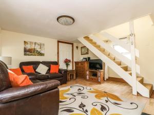 a living room with a couch and a staircase at Manor Farmhouse Cottage in Redruth