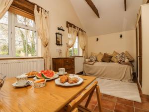 a kitchen and living room with a table with food on it at Manor Farmhouse Cottage in Redruth