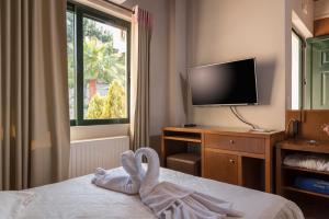 a hotel room with a bed and a television at Villa Myrtia by PosarelliVillas in Kipárissos