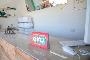 een boek bovenop een bureau met een laptop bij OYO Hotel Plaza Las Torres, Cabo San Lucas in Cabo San Lucas