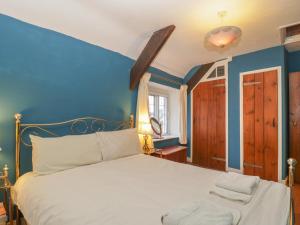 a bedroom with a white bed and blue walls at 2 Lime Street in Bridgwater