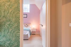 um quarto com uma cama e uma porta que leva a um quarto em The Kennels by Bloom Stays em Faversham
