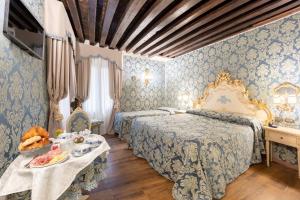 a bedroom with two beds and a table with food on it at Residenza La Loggia in Venice