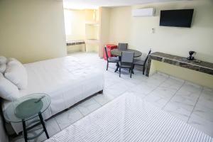 A bed or beds in a room at OYO Hotel Plaza Las Torres, Cabo San Lucas