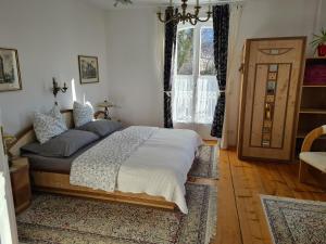 Schlafzimmer mit einem Bett, einem Fenster und einer Tür in der Unterkunft Villa Bariole in Bad Reichenhall
