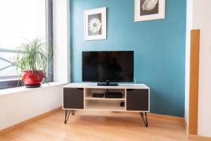 a tv on a stand in a living room at Appartement rien que pour vous proche centre ville in Laval