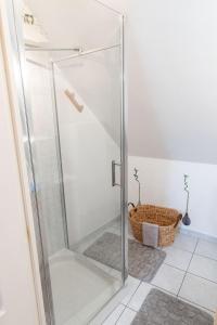 a glass shower stall in a bathroom with a basket at Appartement rien que pour vous proche centre ville in Laval