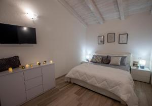 ヴァッレドーリアにあるVilla Orchideaのベッドと壁にテレビが掛かった寝室