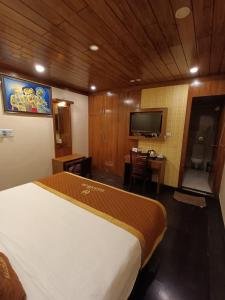 a hotel room with a bed and a television at Aalcajars Inn in Patna