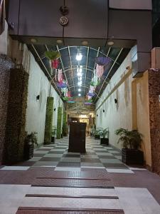 a hallway of a building with a ceiling with plants at Aalcajars Inn in Patna