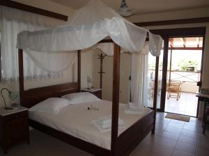 ein Schlafzimmer mit einem großen Bett mit Baldachin in der Unterkunft Villa Helidoni in Pondikianá