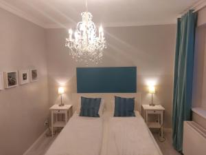 a bedroom with a large bed and a chandelier at Apartmenthaus Franzis in Bad Gastein