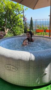 kobieta i dziecko w wannie z hydromasażem w obiekcie Residenza Buggiano Antica B&B - Charme Apartment in Tuscany w mieście Borgo a Buggiano