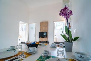 un tavolo con piatti e tazze e un vaso con fiori viola di Marina Julia Family Camping Village a Marina Julia