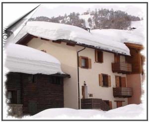 ein Haus mit Schnee darüber in der Unterkunft Baita Carosello Apt 4 Adiacente Carosello 3000 in Livigno