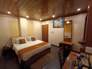 a bedroom with a bed and a desk at Aalcajars Inn in Patna