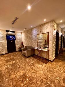 una hall con divano e specchio sul muro di فندق زهرة الربيع zahrat alrabie Hotel a Gedda