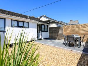 a house with a patio with a table and chairs at Little Starboard in Kingsbridge