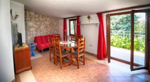 a dining room with a table and chairs and a window at Apartments Coki in Funtana