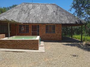 a small brick building with a grass roof at Eagle's Crest in Marloth Park