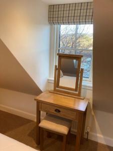 a dressing table with a mirror on it next to a window at Kingfisher Cottage, Port o Tay in Pitlochry