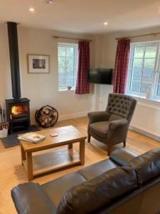 un soggiorno con divano e camino di Kingfisher Cottage, Port o Tay a Pitlochry