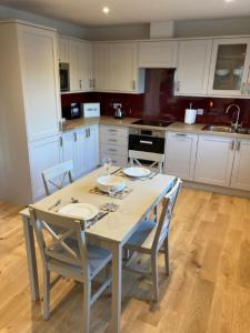 a kitchen with a table with chairs and a sink at Kingfisher Cottage, Port o Tay in Pitlochry