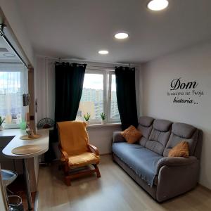 ein Wohnzimmer mit einem Sofa und einem Tisch in der Unterkunft Apartament Hetmańska in Wałbrzych