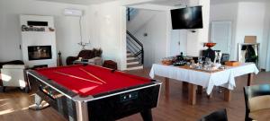 a living room with a pool table and a dining room at Casa Comilor in Şurdeşti