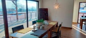 a dining room with a table and a large window at Casa Comilor in Şurdeşti
