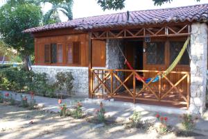 a small building with a porch with flowers in front of it at Cabaña Condominio Campestre ente Santa Marta Rodadero con Piscina WIFI AC in Santa Marta