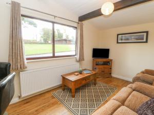 ein Wohnzimmer mit einem Sofa und einem TV in der Unterkunft Bluebell Lodge in Saltburn-by-the-Sea