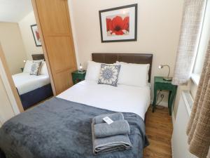 małą sypialnię z łóżkiem i lustrem w obiekcie Bluebell Lodge w mieście Saltburn-by-the-Sea