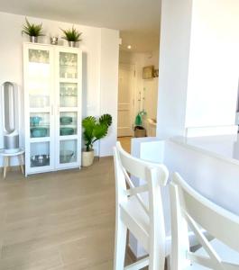 une salle à manger blanche avec une table et des chaises dans l'établissement SUNRISE ESQUINZO, paraíso de sol & playa & paz, à Playa Jandía