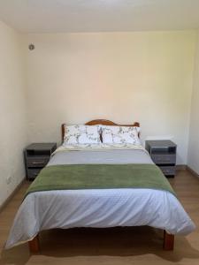 um quarto com uma cama com duas mesas de cabeceira em Casa da Inês em Monte Verde