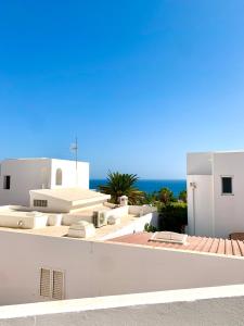 a white building with the ocean in the background at SUNRISE ESQUINZO, paraíso de sol & playa & paz in Playa Jandia