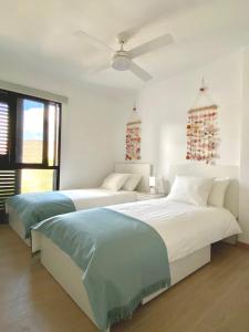 two beds in a bedroom with christmas decorations at SUNRISE ESQUINZO, paraíso de sol & playa & paz in Playa Jandia