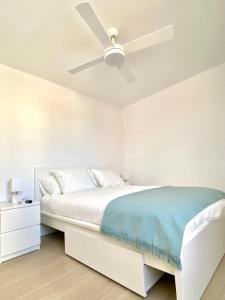 a bedroom with a white bed with a ceiling fan at SUNRISE ESQUINZO, paraíso de sol & playa & paz in Playa Jandia