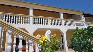 a white house with a balcony and a statue at Apartments Roberta in Kožino