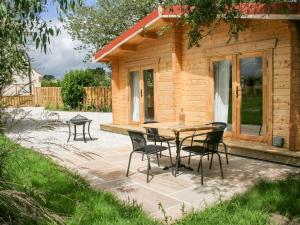 a patio with a table and chairs in front of a cabin at Gardener's Lodge in York