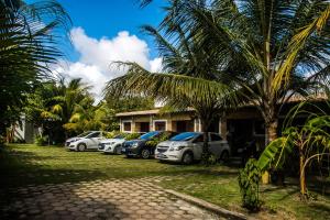 una fila de autos estacionados frente a una casa en Chalés Pipa, en Pipa