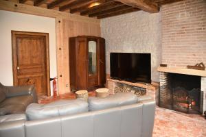 uma sala de estar com um sofá e uma lareira em Chez Maman em Beugnon