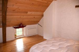 a bedroom with a bed and a wooden ceiling at Chez Maman in Beugnon +16 photos