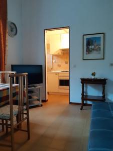 ein Wohnzimmer mit einem Sofa, einem TV und einem Tisch in der Unterkunft casa ubaldo in Cannero Riviera