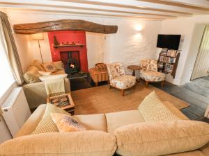 a living room with a couch and a fireplace at Penlanfach Farmhouse in Hermon