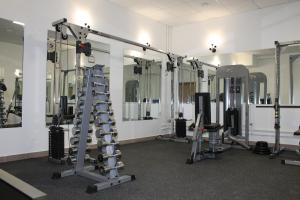 une salle de sport avec plusieurs tapis de course et miroirs dans l'établissement Flagman Hotel, à Novovolkovo