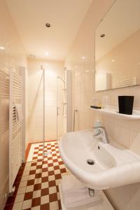 een witte badkamer met een wastafel en een douche bij Herberg de Compagnie in Enkhuizen