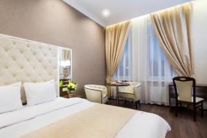 una camera d'albergo con letto, tavolo e sedie di BonApart Hotel by UHM a Kiev