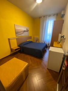 een slaapkamer met een blauw bed en een gele muur bij B&b Al Porto Novo in Bisceglie
