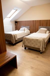 a bedroom with two beds and a skylight at Vánkos & Eszcájg in Újhartyán